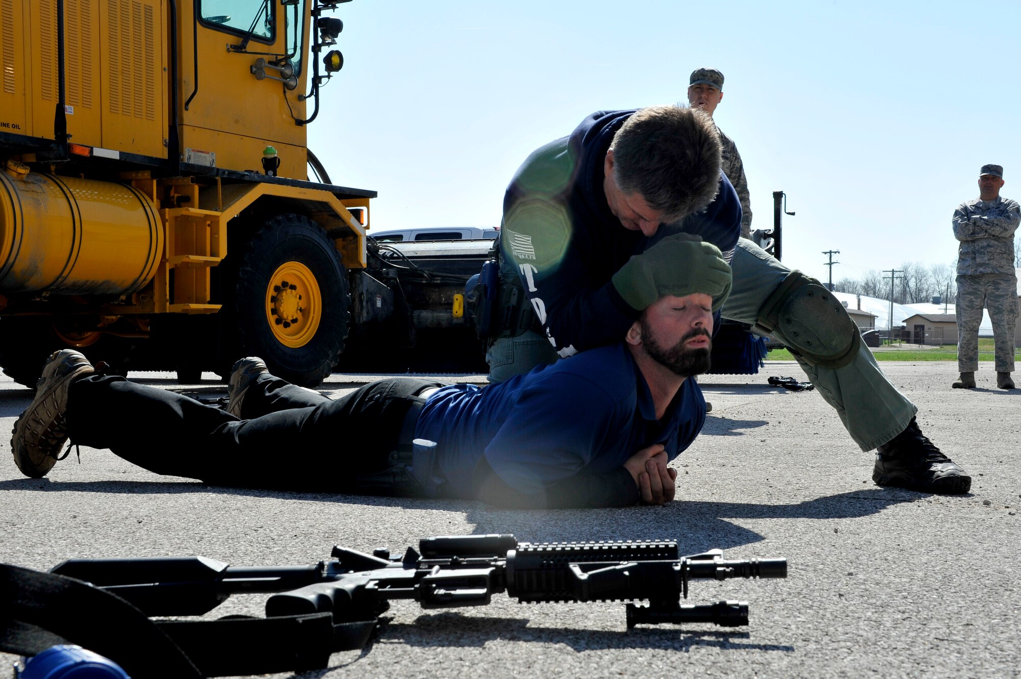 Ken Good, a former Navy SEAL, demonstartes to Security Forces Squadron Airmen and law enforcement members how to arrest someone safely, who is already on the ground during Progressive Combat Solutions training at Scott Air Force Base, Ill., April 8, 2014. The Progressive Combat Solutions trains military and law enforcement personnel in decision making process originally benchmarked by the Air Force known as observe, orient, decide and act. The Air Mobility Command and the 375th Security Force Squadron hosted this training with the goal of implementing it across the AMC command in the future. (U.S. Air Force photo/Airman 1st Class Kiana Brothes)
