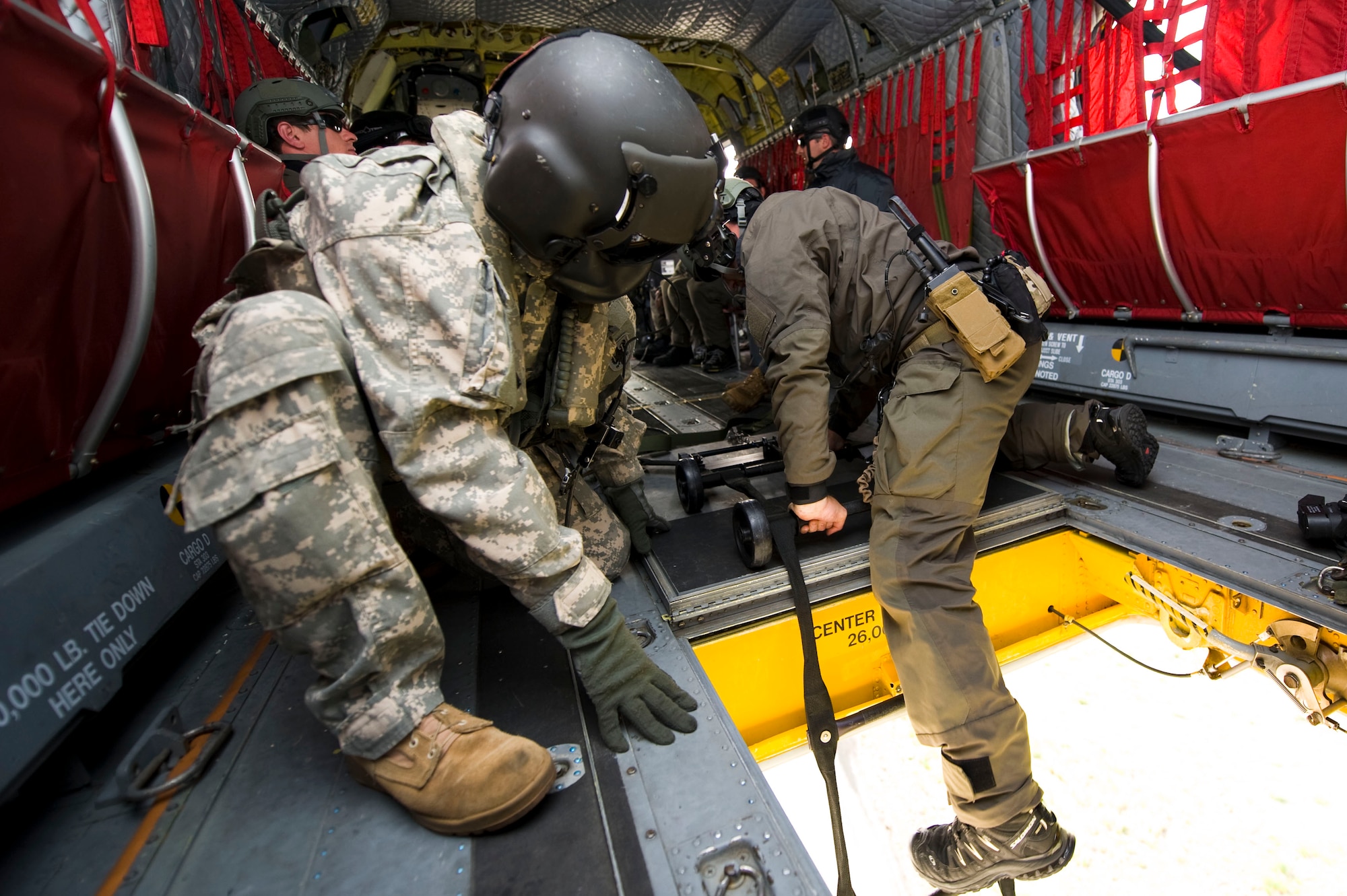 A 5-159th General Support Aviation Battalion CH-47 Chinook technician helps a U.S. Navy Special Boat Team 20 Sailor climb into the helicopter during a training exercise at Fort Eustis, Va., April 11, 2014. The Chinook team loaded a fast-attack craft via cables to practice extraction procedures. (U.S. Air Force photo by Senior Airman Austin Harvill/Released) 