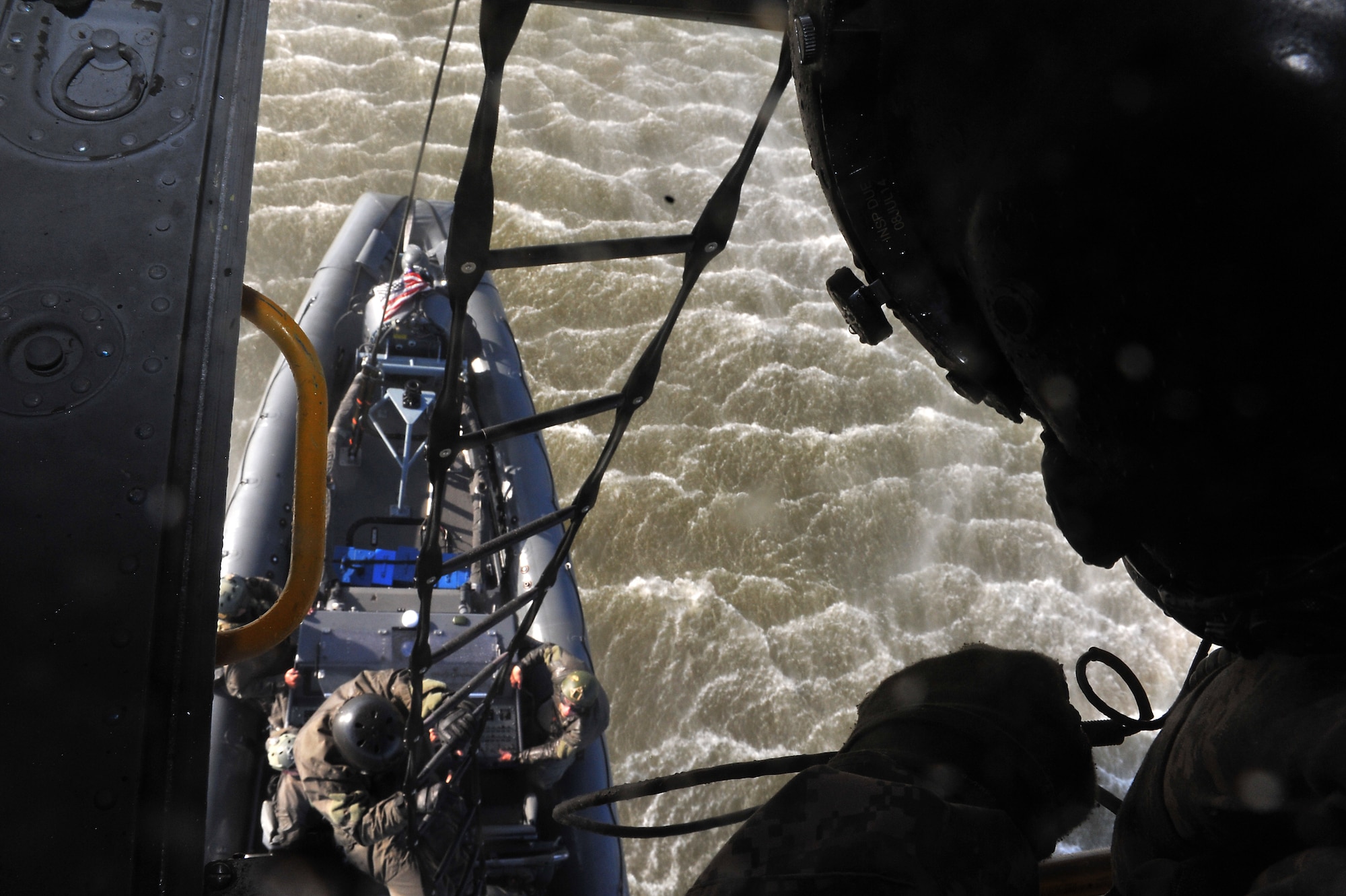 A 5-159th General Support Aviation Battalion CH-47 Chinook technician awaits the signal from U.S. Navy Special Boat Team 20 Sailors for cable release during a training exercise at Fort Eustis, Va., April 10, 2014. The exercise lasted five days to train multiple personnel on proper sling-loading techniques. (U.S. Air Force photo by 2nd Lt. Brooke Betit/Released) 