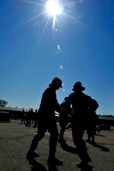Security Forces Squadron trainers practice defense strategies during Progressive Combat Solutions training at Scott Air Force Base, Ill., April 8, 2014. This training scenario will prepare members on how to defend themselves when a single person tries to take their weapon. The Progressive Combat Solutions trains military and law enforcement personnel in decision making process originally benchmarked by the Air Force known as observe, orient, decide and act. This training scenario will prepare members on how to defend themselves when a single person tries to take their weapon. The Air Mobility Command and the 375th Security Force Squadron hosted this training with the goal of implementing it across the AMC command in the future. (U.S. Air Force photo/Airman 1st Class Kiana Brothers)
