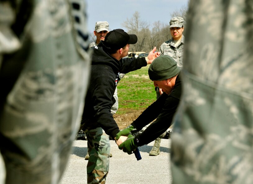 Ken Good, a former Navy SEAL, instructs Security Forces Squadron Airmen and law enforcement members how to defend themselves when someone is trying to take their weapon during Progressive Combat Solutions training at Scott Air Force Base, Ill., April 8, 2014. The Progressive Combat Solutions trains military and law enforcement personnel in decision making process originally benchmarked by the Air Force known as observe, orient, decide and act. The Air Mobility Command and the 375th Security Force Squadron hosted this training with the goal of implementing it across the AMC command in the future. (U.S. Air Force photo/Staff Sgt. Stephenie Wade)