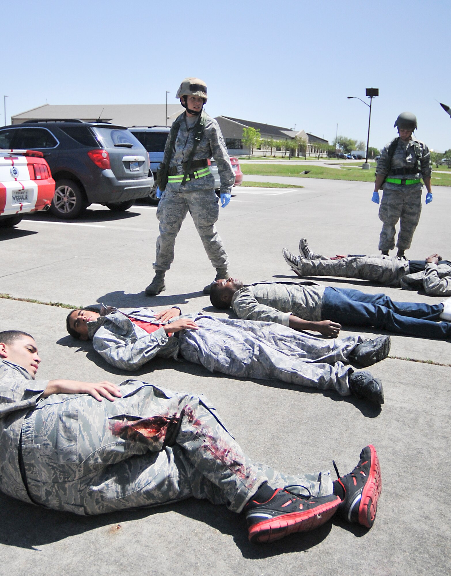 Members of the 147th Reconnaissance Wing Student Flight play the rolls of victims during a mass casualty scenario as part of an Operational Readiness Exercise April 4, 2014 at Ellington Field Joint Reserve Base, Houston, TX. Tech Sgt. Erin Young (standing left) and Tech Sgt. Courtney Bosch (standing right), 147th Medical Group begin the triage of the simulated victims prior to transport. The mass casualty scenario test both the 147th Fire Department and 147th Medical Group's ability to respond to a real world emergency.