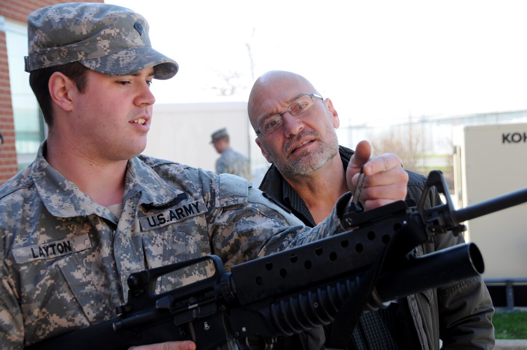 Army Specialist Layton explains the operation of rifle with a granade launcher attached to an employer as part of Operation Joint Engagement April 10, at the Springfield Air National Guard Base, Ohio. The event showcased the Ohio National Guard's capabilities to guardmember's civilian employers. (Ohio Air National Guard photo by Senior Master Sgt. Joseph Stahl/Released)
