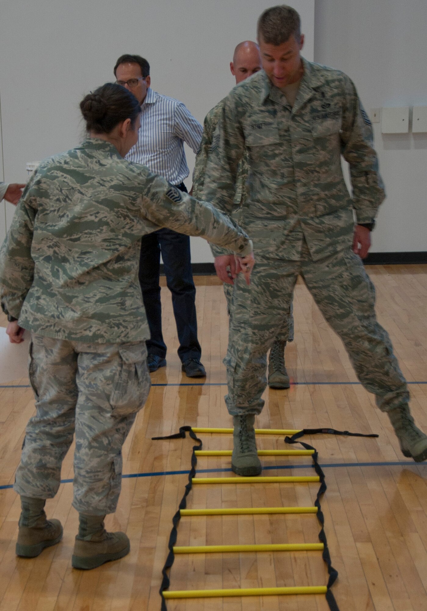 140415-F-GZ967-022 Chief Master Sgt. Wayne Stott, 90th Medical Group command chief, learns the proper way to go through the ladder stepper obstacle of the Sexual Assault Awareness Month confidence course April 15 in the Freedom Hall Fitness Center. With a unique step design, the ladder stepper was one of the harder obstacles in the course. (U.S. Air Force photo by Airman 1st Class Brandon Valle)