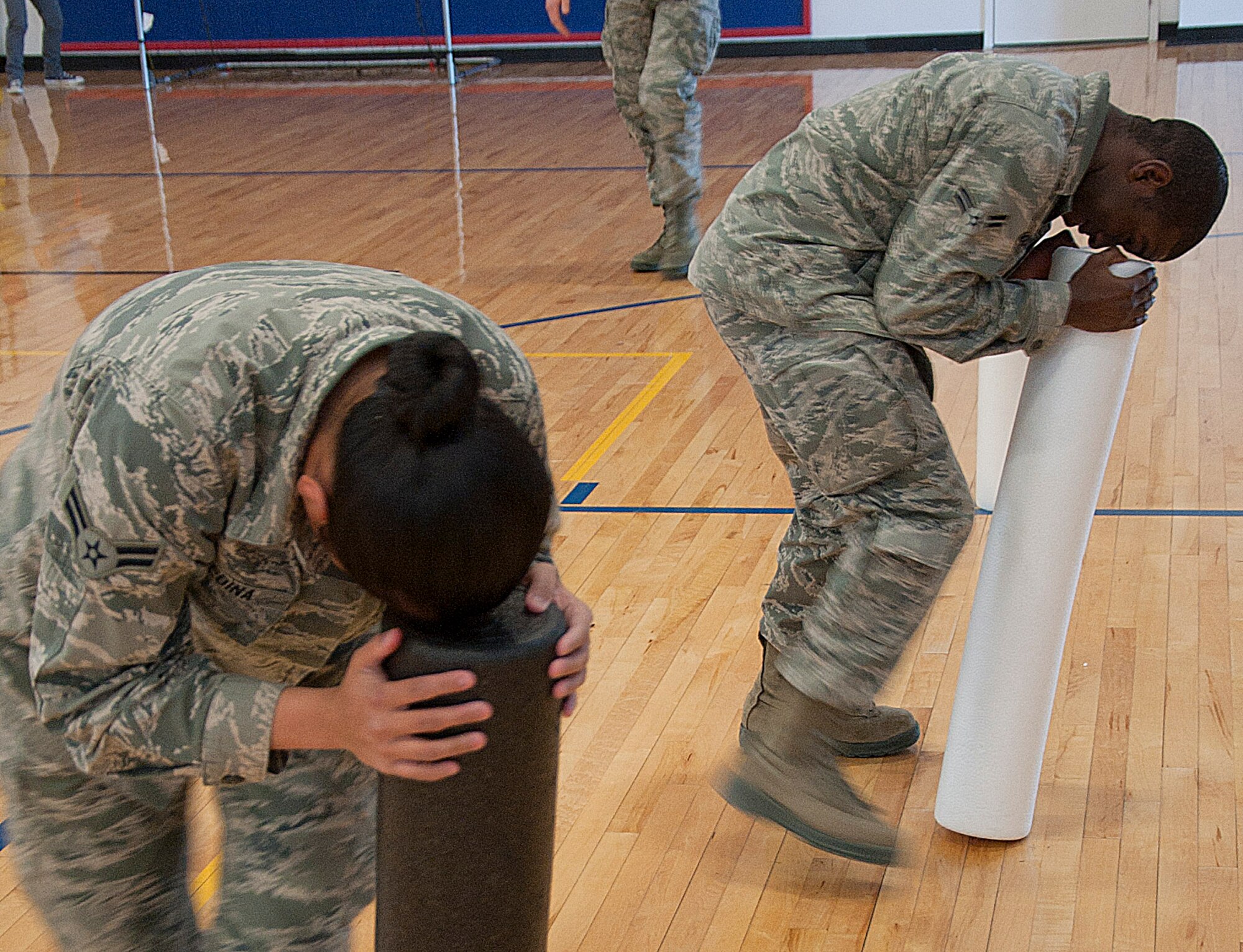 140415-F-GZ967-013 Airmen 1st Class Andrew Madden and Jonaelisha Medina, 90th Comptroller Squadron, participate in the foam roller spin obstacle of the Sexual Assault Awareness Month confidence course April 15 in the Freedom Hall Fitness Center. (U.S. Air Force photo by Airman 1st Class Brandon Valle)