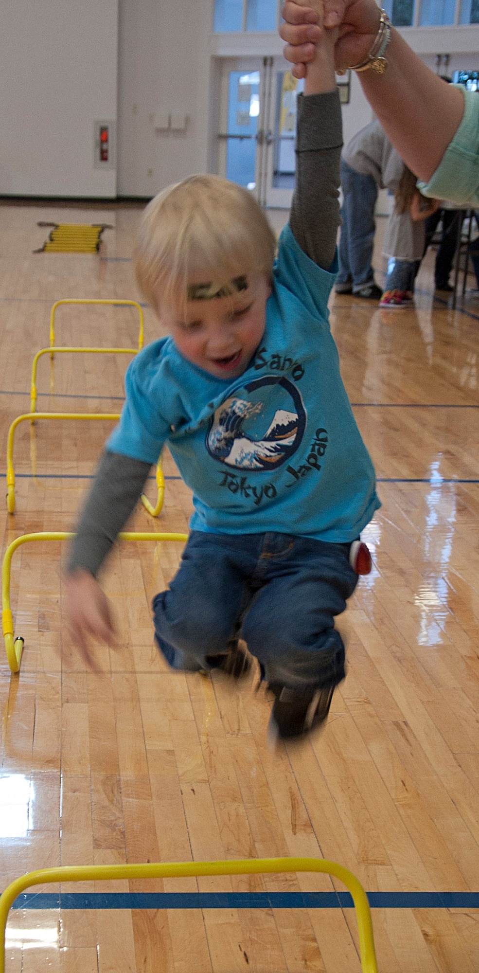 140415-F-GZ967-010 Will Flint, 3, son of Col. Trevor Flint, 90th Maintenance Group commander, shows off his jumping skills as he leaps over hurdles April 15 during the Sexual Assault Awareness Month confidence course in the Freedom Hall Fitness Center. The course had 10 various obstacles that were designed for participants of all ages to complete. (U.S. Air Force photo by Airman 1st Class Brandon Valle)