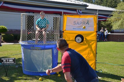 Petty Officer 1st Class Chris Bryant, an electrician’s mate and staff member assigned to the Naval Nuclear Power Training Command, and Sexual Assault Prevention and Response victim advocate, takes his place in a dunk tank to raise money for Sexual Assault Awareness Month  April 11, 2014 during the NNPTC bi-monthly barracks bash cookout on Joint Base Charleston – Weapons Station, S.C.  During the event, the SAPR team helped raise $2,300 for victim assistance and sexual assault education. (US Navy photo /Petty Officer 3rd Class Jason Pastrick)