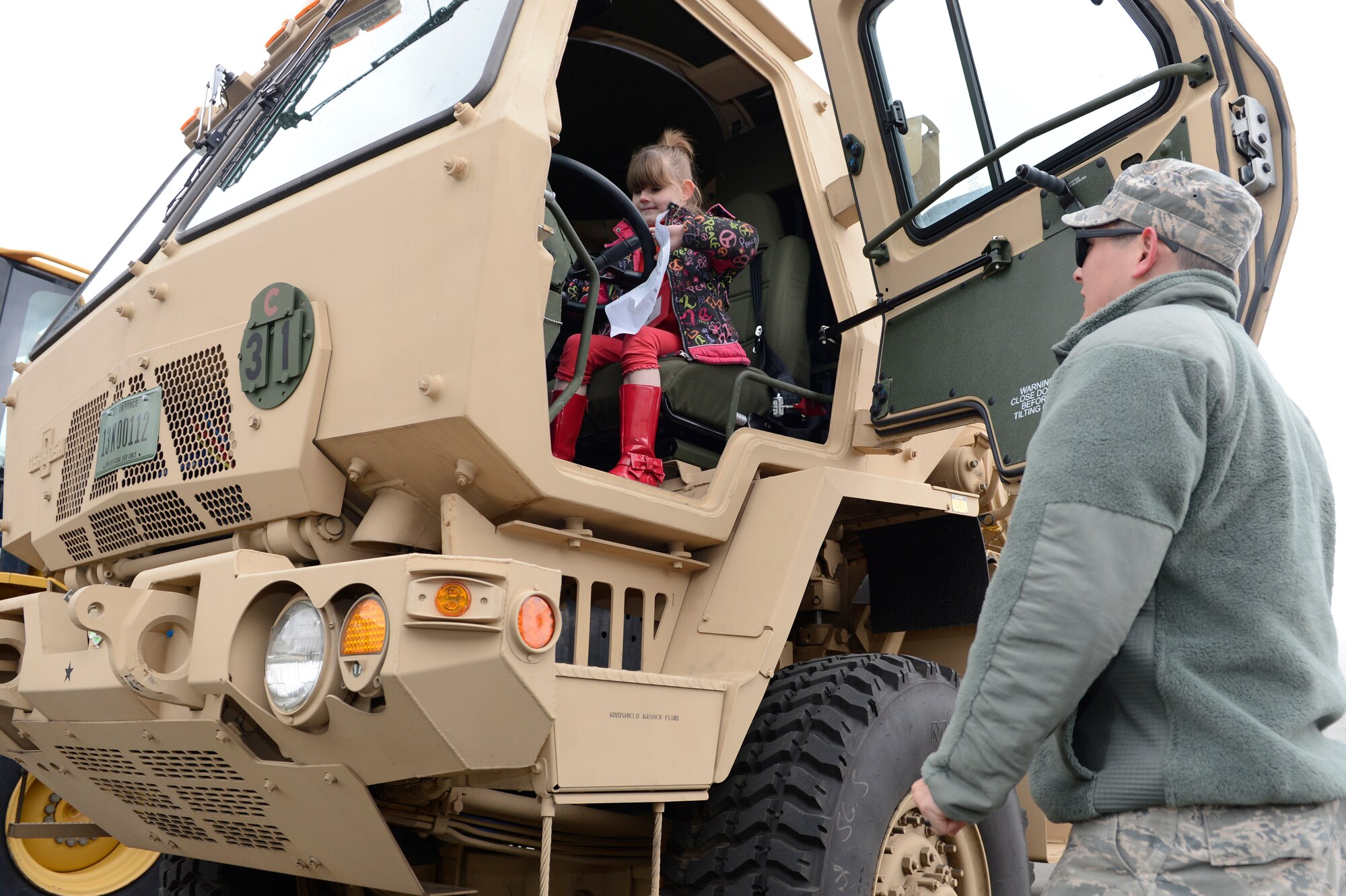 Hannah Dickson, daughter of Shannon and Tech. Sgt. Todd Dickson, 52nd Equipment Maintenance Squadron, pretends to drive a military vehicle during Kids' Deployment Day at Spangdahlem Air Base, Germany, April 15, 2014. Children interacted with multiple vehicles including security forces patrol cars and a fire truck. (U.S. Air Force photo by Staff Sgt. Christopher Ruano/Released)