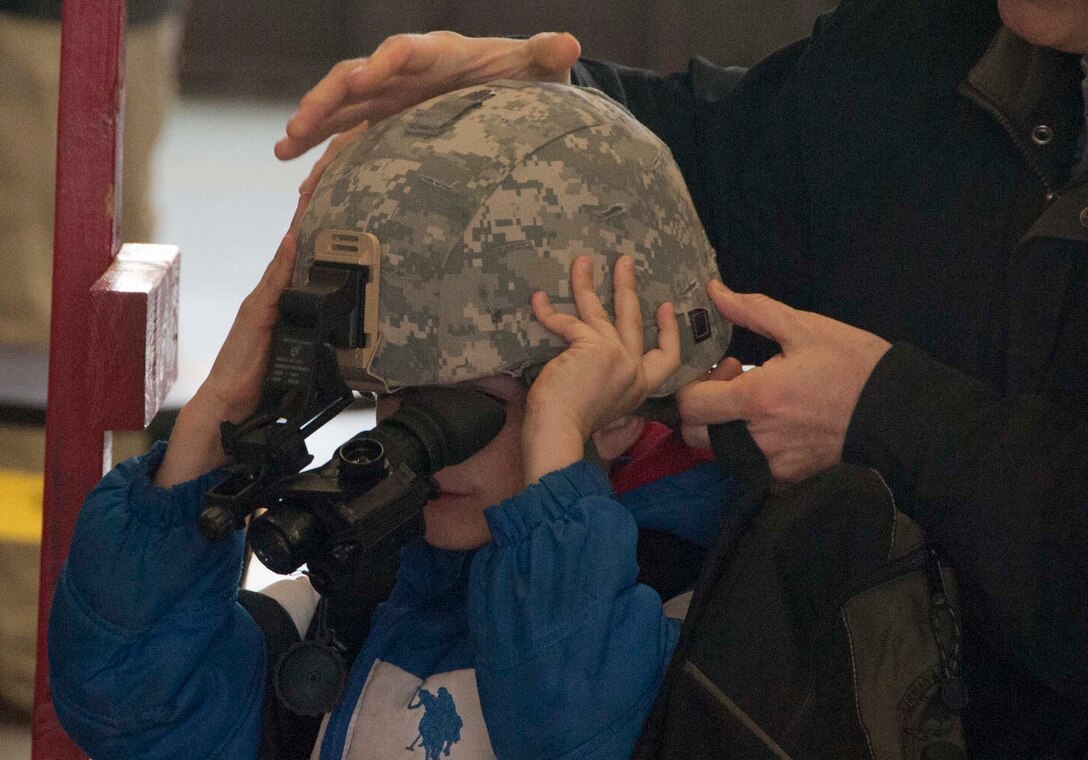 Military dependent children get hands on with Kevlar helmets equipped with night vision goggles during Operations KIDS (Kids Investigating Deployment Services) April 5, at Sheppard Air Force Base. Operation KIDS gave children an opportunity to achieve a better perspective and understanding on what their parents go through during a deployment. (U.S. Air Force photo/Airman 1st Class Robert L. McIlrath)