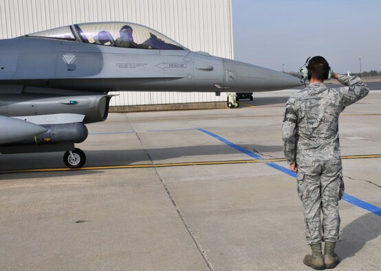 From left, Lt. Gen. William H. Etter, Commander of Continental U.S. North American Aerospace Defense Command Region - 1st Air Force, piloting an F-16 Fighting Falcon salutes Staff Sgt. Ben Ellis, crew chief from the New Jersey Air National Guard's 177th Fighter Wing at the Atlantic City Air Guard Base, upon marshalling the aircraft for taxiing on April 3, 2014. (U.S. Air National Guard photo by Master Sgt. Andrew J. Moseley/Released)