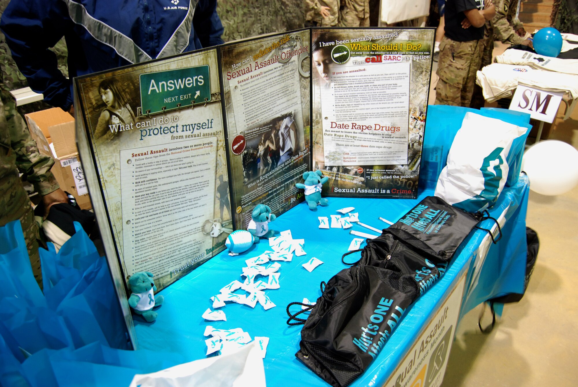 An information booth displays sexual assault prevention and reporting information at the Sexual Assault Awareness Month 5K pre-race registration area at Bagram Airfield, Afghanistan, April 4, 2014. The goal of the event was to highlight awareness of sexual assault prevention and reporting methods. (U.S. Air Force photo by Capt. Brian Wagner/Released)