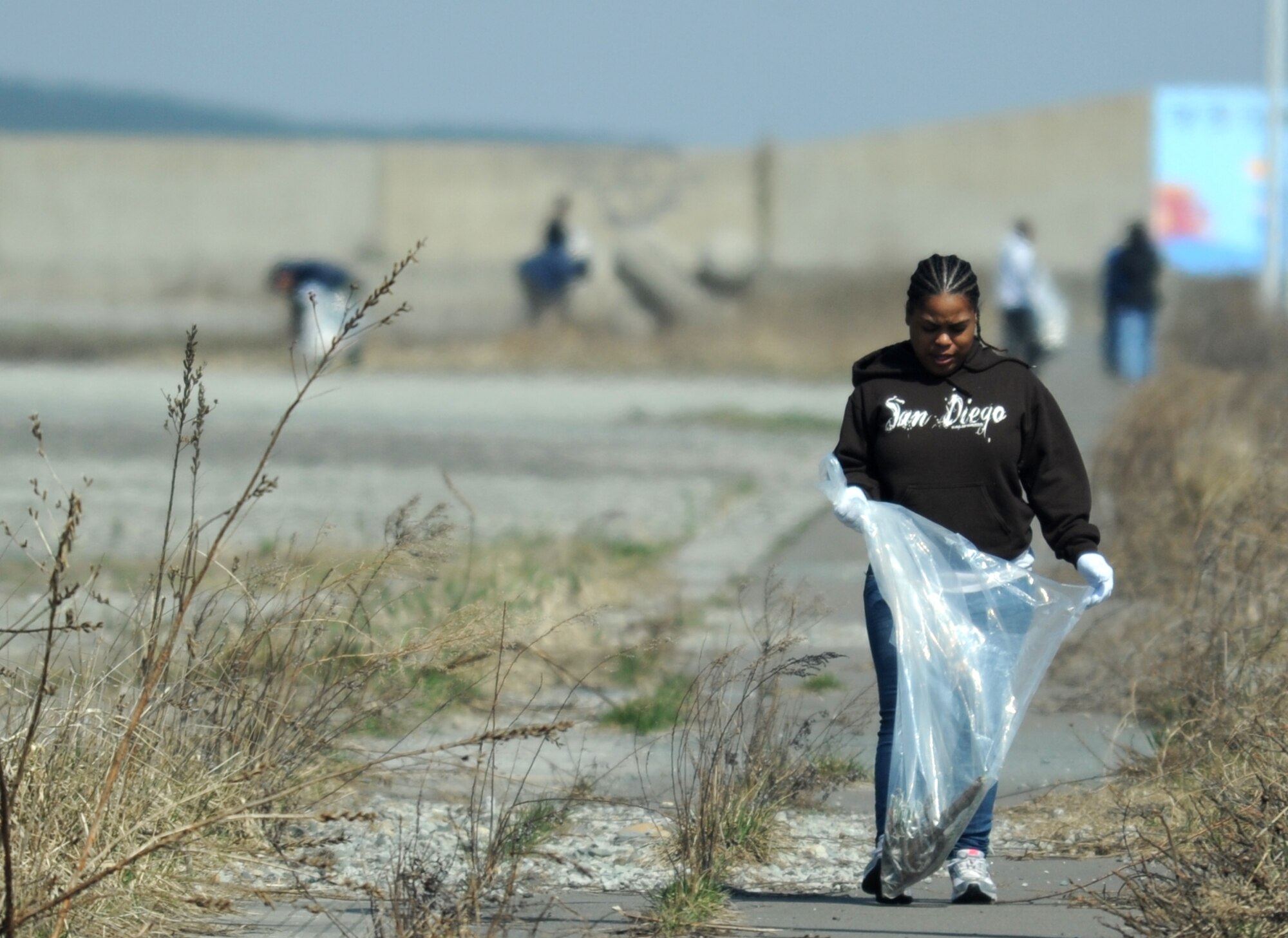 U. S. Navy Petty Officer 2nd Class Dorian Duncan, Aircraft Intermediate Maintance Detachment Misawa maintenance administrative clerk, picks up trash during the 17th Annual Misawa Fish Port Cleanup in Misawa City, Japan, April 12, 2014. More than 500 volunteers from both Misawa Air Base and Misawa City came together and collected about 9,000 pounds of trash in support of Earth Day and Japan’s Greenery Day, hosted by 35th Civil Engineer Squadron environmental engineers. (U.S. Air Force Tech. Sgt. April Quintanilla)