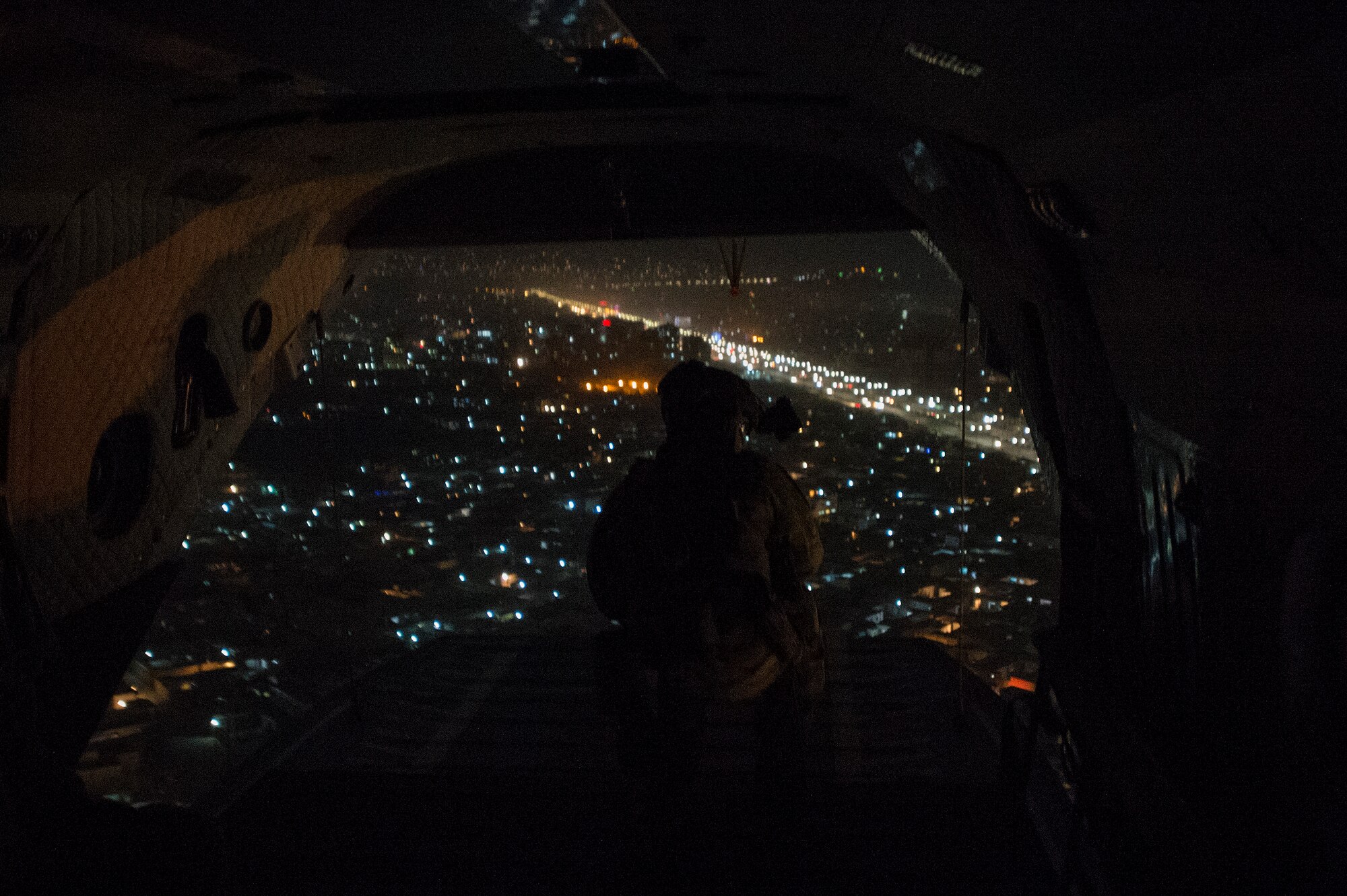 U.S. Air Force Staff Sgt. Josh Martin, 438th Air Expeditionary Wing/NATO Air Training Command-Afghanistan Mi-17 adviser, scans for threats during a night vision goggle training mission flown with the Afghan air force in Kabul, Afghanistan, March 13, 2014. Martin, a Rapid City, S.D. native, is deployed from the 55th Rescue Squadron, Davis Monthan, Air Force Base, Ariz. Airmen of the 438th AEW/NATC-A play a vital role in Operation Enduring Freedom as advisers tasked with aiding the Afghan government in establishing an operational and sustainable Afghan Air Force. (U.S. Air Force photo by Tech. Sgt. Jason Robertson/Released)