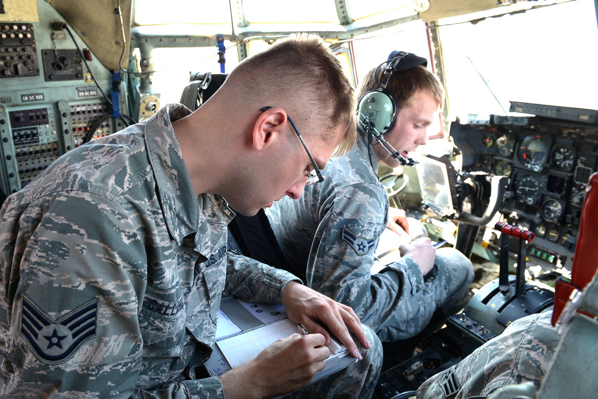 Staff Sgt. Jonathan Callahan, 374th Maintenance Group crew chief quality assurance inspector, performs a personal evaluation of Airman 1st Class Colby McDonald, 374th Aircraft Maintenance Squadron aerospace maintenance journeyman, at Yokota Air Base, Japan, April 8, 2014. McDonald was evaluated on his ability to conduct a propeller oil service check. (U.S. Air Force photo by Airman 1st Class David Danford/Released)
