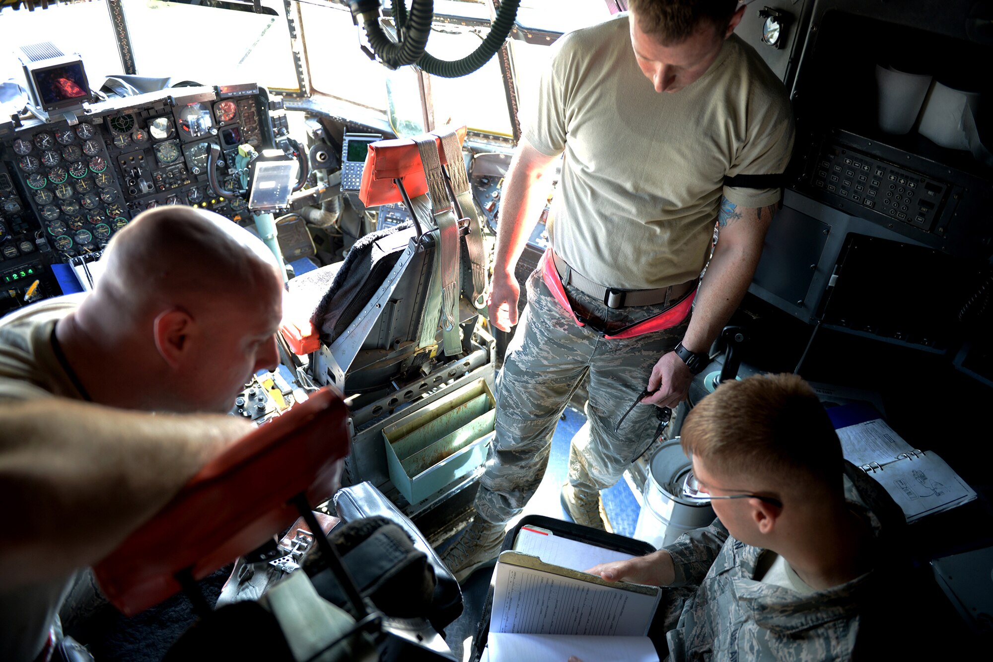 Staff Sgt. Jonathan Callahan, 374th Maintenance Group crew chief quality assurance inspector, reviews procedures with members of the 374th Aircraft Maintenance Squadron at Yokota Air Base, Japan, April 8, 2014.  Callahan carries a binder containing C-130 Hercules maintenance procedures and policies as reference material so that he can provide accurate instruction and evaluation. (U.S. Air Force photo by Airman 1st Class David Danford/Released)