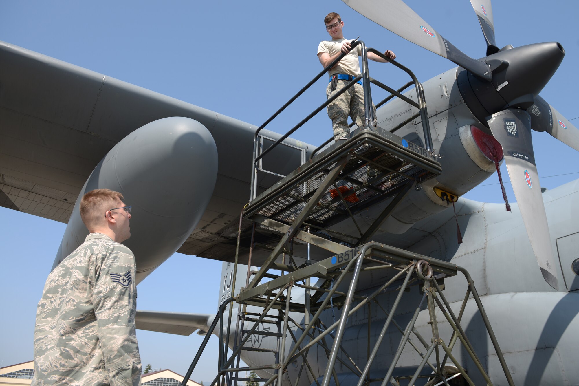 Staff Sgt. Jonathan Callahan, 374th Maintenance Group crew chief quality assurance inspector, speaks with Senior Airman Brandon Hughes, 374th Aircraft Maintenance Squadron aerospace maintenance journeyman, at Yokota Air Base, Japan, April 8, 2014. Members of quality assurance are chosen from within maintenance career fields to ensure that inspections are performed by subject matter experts. (U.S. Air Force photo by Airman 1st Class David Danford/Released)