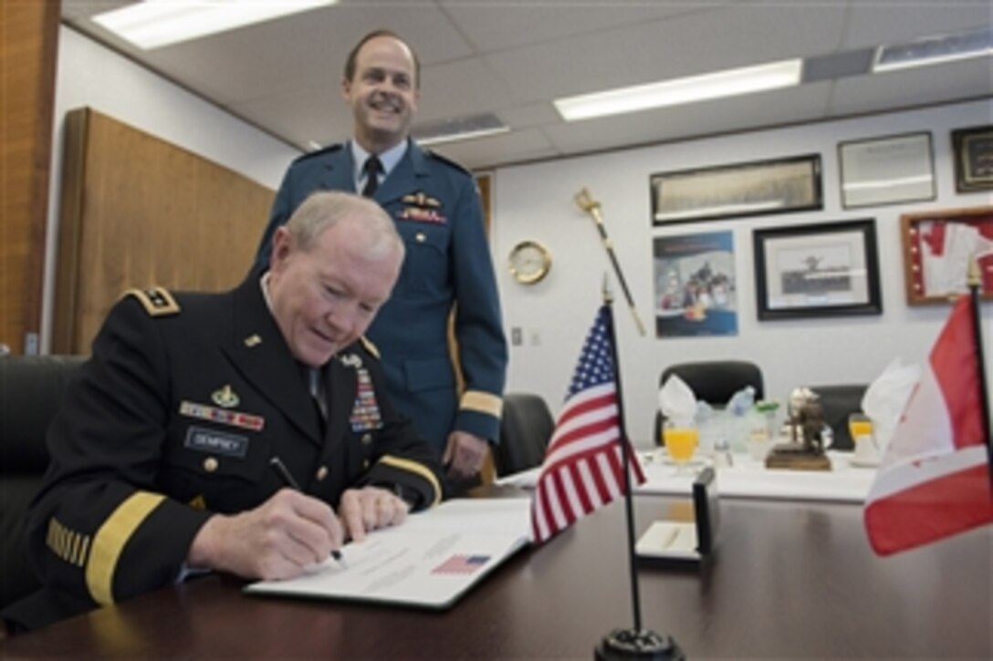 U.S. Army Gen. Martin E. Dempsey, left, chairman of the Joint Chiefs of Staff, signs the guestbook of Canadian Air Force Gen. Thomas J. Lawson, chief of Canada's defense staff, during his three-day visit to Ottawa, Ontario, April 15, 2014.