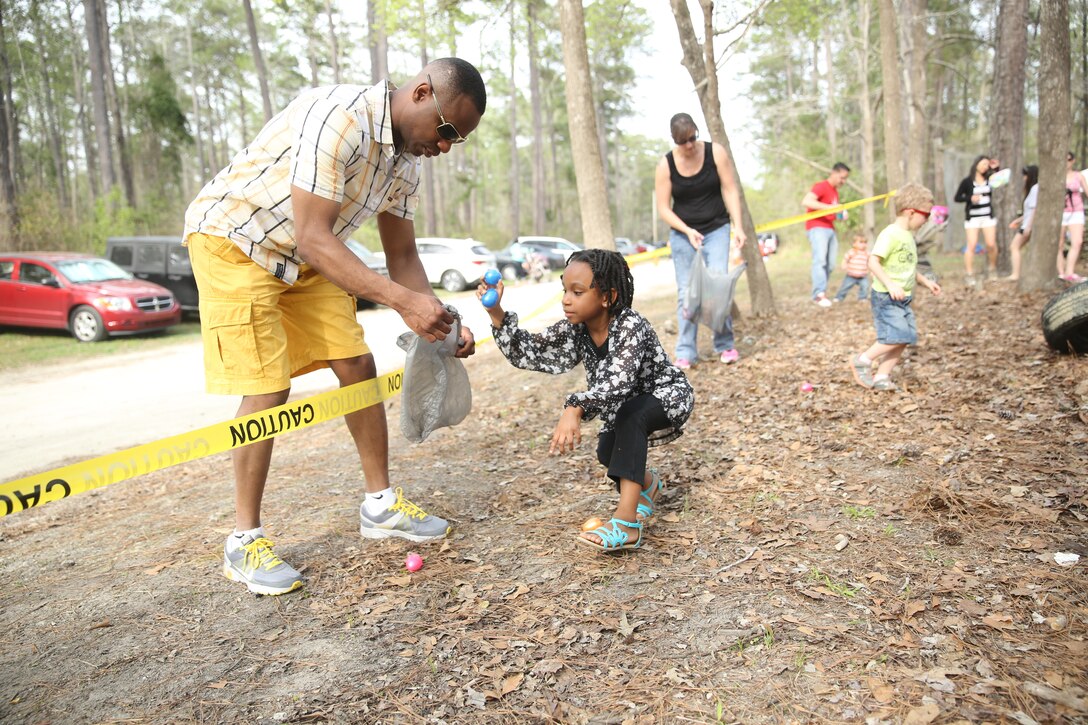 Navy Lt. Kyron Bell assists his daughter during an Easter egg hunt at Marine Corps Air Station Cherry Point, N.C., April 11, 2014. The egg hunt was part of Marine Aircraft Group 14’s fifth annual Easter Eggstravaganza. Bell is the chaplain for MAG-14. 