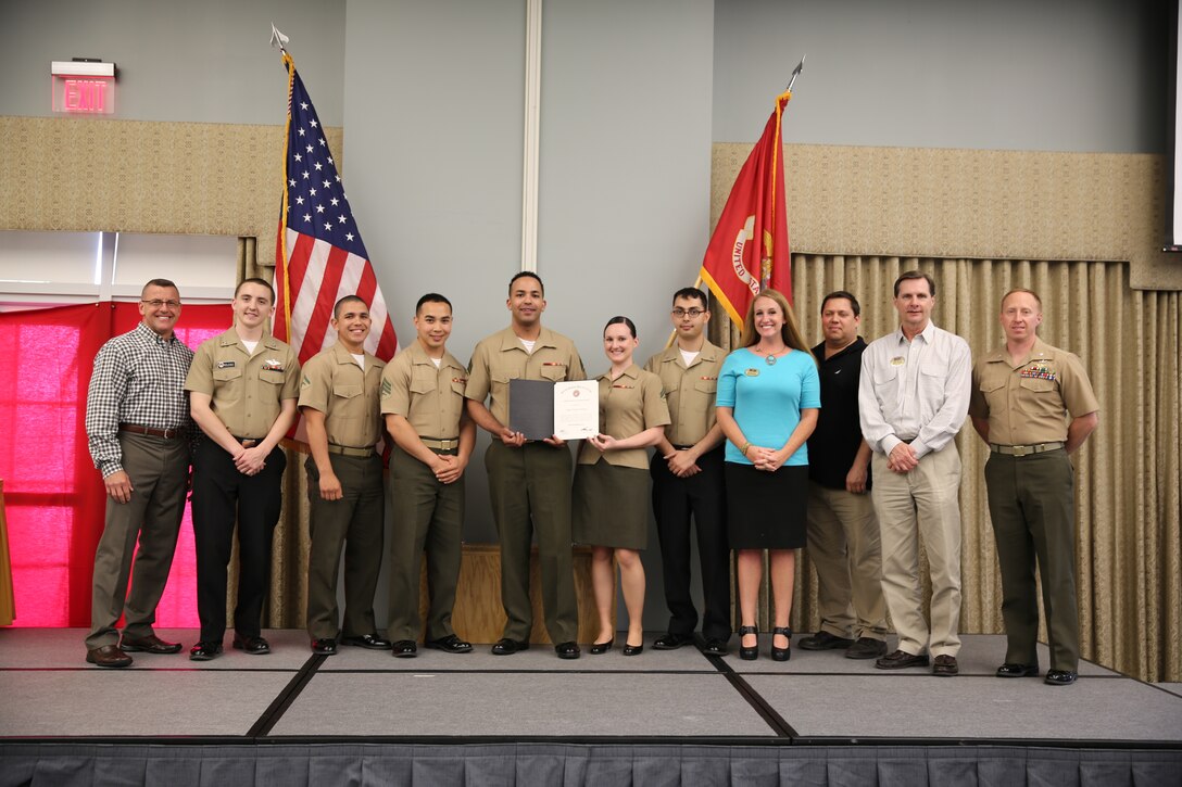 Maj. Gen. Robert F. Hedelund, left, the Single Marine Program volunteers and staff, middle, and Lt. Col. Charles Basham, right, pose for a photo after the Volunteer Appreciation Ceremony at Marine Corps Air Station Cherry Point, N.C., April 11, 2014. The Volunteer Appreciation Ceremony is designed to recognize the station’s volunteers and the volunteer service they contribute to the Marines, their families and the surrounding community.  