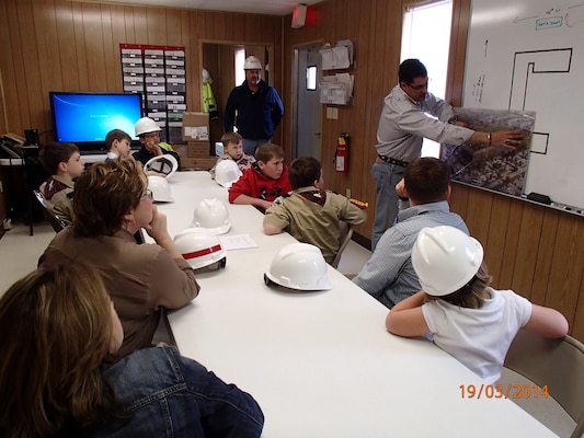 Bill Cottle, Balfour Beatty project manager, shows a troop of Webelos an aerial view artist rendition of the completed EAB Barracks Facility at Fort Campbell.  