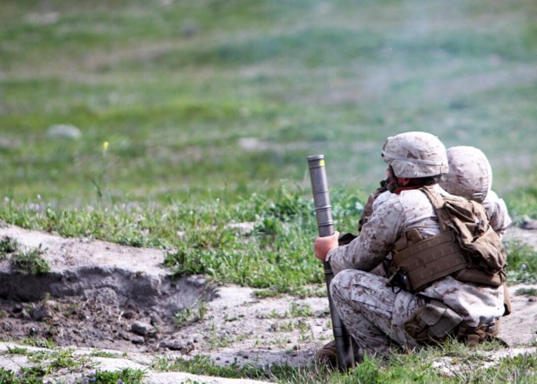 Marines with Weapons Company, 2nd Battalion, 7th Marine Regiment, fire 60 mm mortars during a mortar fire exercise aboard Marine Corps Base Camp Pendleton, Calif., April 4, 2014. The unit, based out of Marine Corps Air Ground Combat Center Twentynine Palms, Calif., came to Camp Pendleton to conduct training on the different types of terrain the base has to offer. After reloading the hand-held mortar, Marines regained their sight alignment before firing the round to ensure accuracy and safety. (U.S. Marine Corps photo by Lance Cpl. Joshua Murray/Released)