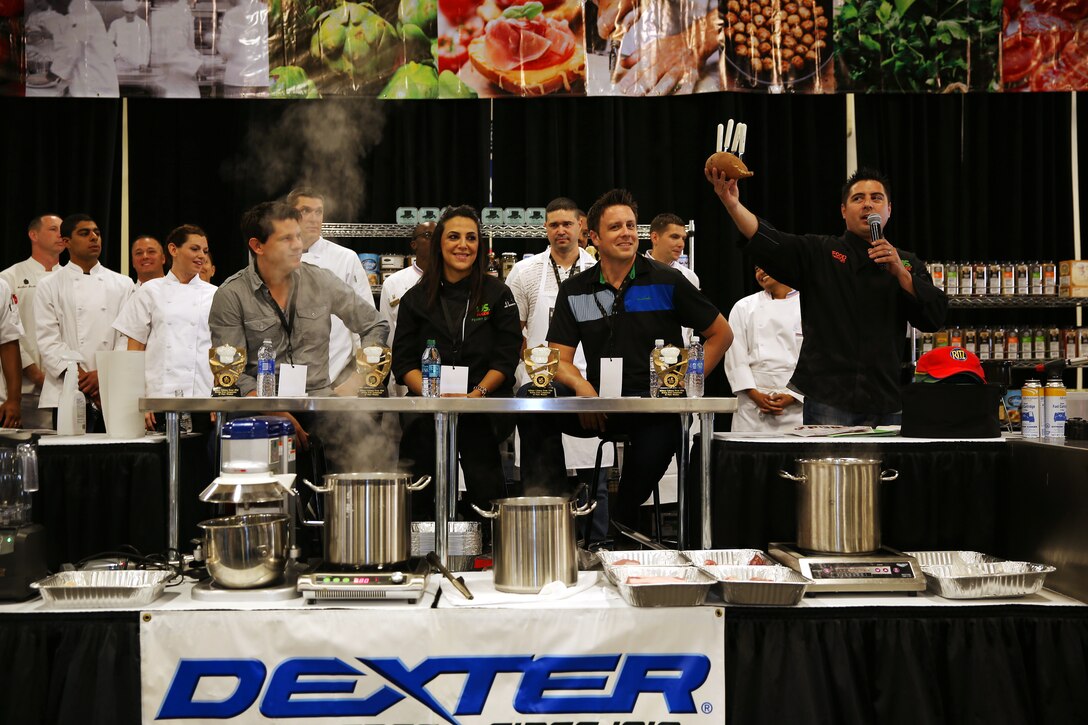 Aaron Williams holds up a sweet potato with knives, which will determine the order the teams will begin cooking at the Boiling Points competition held at the Del Mar Fairgrounds April 16. Boiling Points is a competition hosted by Aaron Williams, the corporate division chef for Food Fanatics, Los Angeles. The competition challenged the Marine Corps, Army, Navy and Coast Guard to go head-to-head in a 45-minute cooking competition. The Marine team took 1st place with their dish of an appetizer of fried eggplant and seared scallop caprese, and an entrée of seared duck, sweet potatoes and a fruit medley with a star fruit and horn melon sauce.