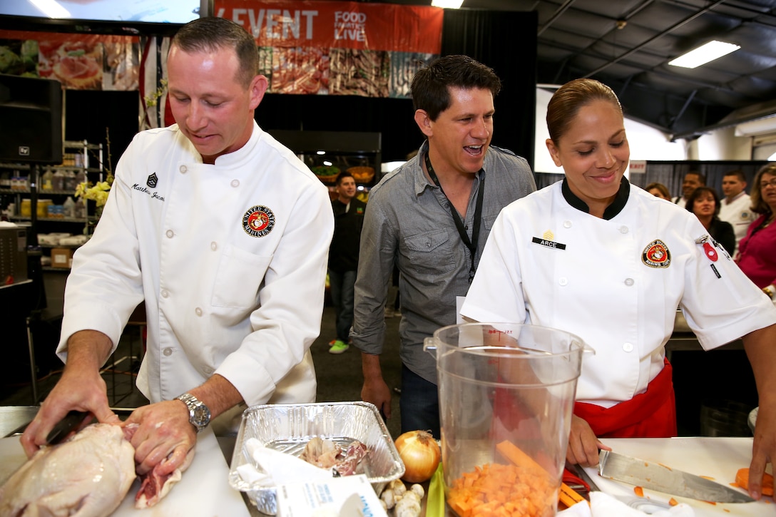 Gunnery Sgt. Matthew Jacobs and Staff Sgt. Karla Arce prepare their meal while judge Troy Johnson taunts them at the Boiling Points competition held at the Del Mar Fairgrounds April 16. Boiling Points is a competition hosted by Aaron Williams, the corporate division chef for Food Fanatics, Los Angeles. The competition challenged the Marine Corps, Army, Navy and Coast Guard to go head-to-head in a 45-minute cooking competition. The Marine team took 1st place with their dish of an appetizer of fried eggplant and seared scallop caprese, and an entrée of seared duck, sweet potatoes and a fruit medley with a star fruit and horn melon sauce. Jacobs is the enlisted aid for the I Marine Expeditionary Force’s commanding general, Arce is the enlisted aide for MCI West and Marine Corps Base Camp Pendleton’s commanding general and Johnson is a Food Network judge.