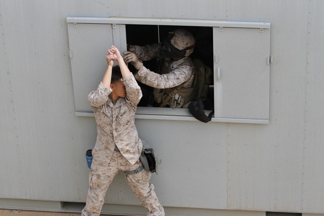Marines participating in the Division School's Urban Leaders Course move from one building to another while carrying a casualty during a squad tactics exercise aboard Marine Corps Base Camp Pendleton, Calif., April 9, 2014. The Marines were conducting a patrol when they received contact from instructors posing as enemies. The exercise included roadside bomb simulations, gas drills and patrols that tested the Marines' proficiency in urban combat tactics. (U.S. Marine Corps photo by Lance Cpl. David Silvano/released)