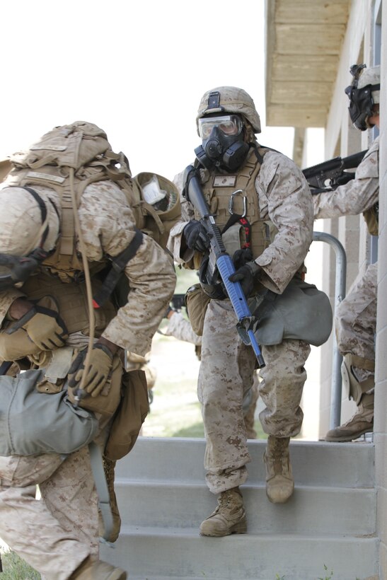 Marines participating in the Division School's Urban Leaders Course move from one building to another while carrying a casualty during a squad tactics exercise aboard Marine Corps Base Camp Pendleton, Calif., April 9, 2014. The Marines were conducting a patrol when they received contact from instructors posing as enemies. The exercise included roadside bomb simulations, gas drills and patrols that tested the Marines' proficiency in urban combat tactics. (U.S. Marine Corps photo by Lance Cpl. David Silvano/released)