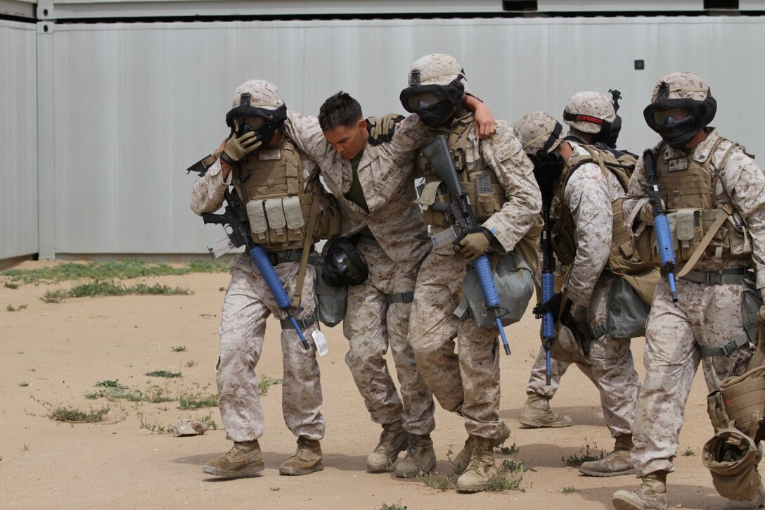 Marines participating in the Division School's Urban Leaders Course move from one building to another while carrying a casualty during a squad tactics exercise aboard Marine Corps Base Camp Pendleton, Calif., April 9, 2014. The Marines were conducting a patrol when they received contact from instructors posing as enemies. The exercise included roadside bomb simulations, gas drills and patrols that tested the Marines' proficiency in urban combat tactics. (U.S. Marine Corps photo by Lance Cpl. David Silvano/released)