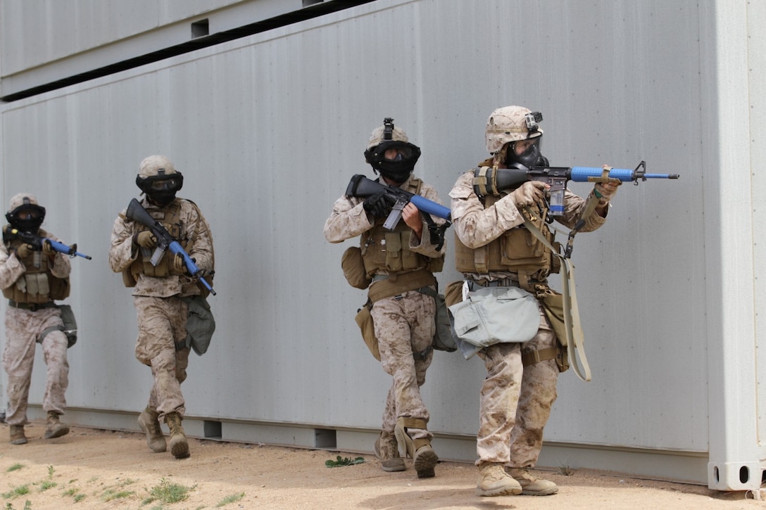 Marines participating in the Division School's Urban Leaders Course move from one building to another while carrying a casualty during a squad tactics exercise aboard Marine Corps Base Camp Pendleton, Calif., April 9, 2014. The Marines were conducting a patrol when they received contact from instructors posing as enemies. The exercise included roadside bomb simulations, gas drills and patrols that tested the Marines' proficiency in urban combat tactics. (U.S. Marine Corps photo by Lance Cpl. David Silvano/released)