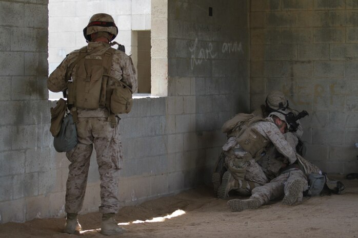 Marines participating in the Division School's Urban Leaders Course move from one building to another while carrying a casualty during a squad tactics exercise aboard Marine Corps Base Camp Pendleton, Calif., April 9, 2014. The Marines were conducting a patrol when they received contact from instructors posing as enemies. The exercise included roadside bomb simulations, gas drills and patrols that tested the Marines' proficiency in urban combat tactics. (U.S. Marine Corps photo by Lance Cpl. David Silvano/released)