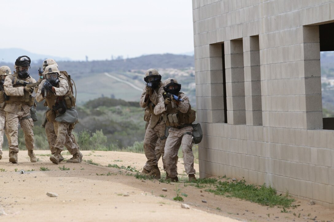 Marines participating in the Division School's Urban Leaders Course move from one building to another while carrying a casualty during a squad tactics exercise aboard Marine Corps Base Camp Pendleton, Calif., April 9, 2014. The Marines were conducting a patrol when they received contact from instructors posing as enemies. The exercise included roadside bomb simulations, gas drills and patrols that tested the Marines' proficiency in urban combat tactics. (U.S. Marine Corps photo by Lance Cpl. David Silvano/released)