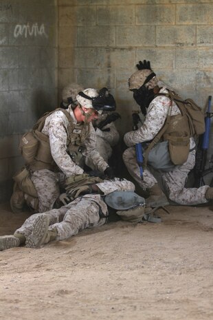 Marines participating in the Division School's Urban Leaders Course move from one building to another while carrying a casualty during a squad tactics exercise aboard Marine Corps Base Camp Pendleton, Calif., April 9, 2014. The Marines were conducting a patrol when they received contact from instructors posing as enemies. The exercise included roadside bomb simulations, gas drills and patrols that tested the Marines' proficiency in urban combat tactics. (U.S. Marine Corps photo by Lance Cpl. David Silvano/released)