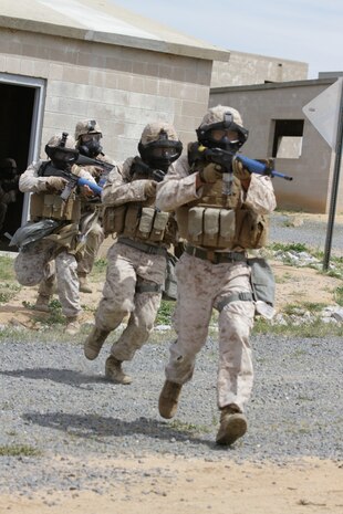 Marines participating in the Division School's Urban Leaders Course move from one building to another while carrying a casualty during a squad tactics exercise aboard Marine Corps Base Camp Pendleton, Calif., April 9, 2014. The Marines were conducting a patrol when they received contact from instructors posing as enemies. The exercise included roadside bomb simulations, gas drills and patrols that tested the Marines' proficiency in urban combat tactics. (U.S. Marine Corps photo by Lance Cpl. David Silvano/released)