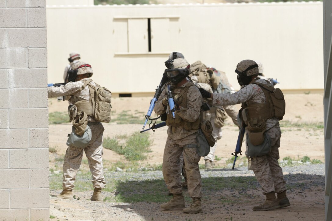 Marines participating in the Division School's Urban Leaders Course move from one building to another while carrying a casualty during a squad tactics exercise aboard Marine Corps Base Camp Pendleton, Calif., April 9, 2014. The Marines were conducting a patrol when they received contact from instructors posing as enemies. The exercise included roadside bomb simulations, gas drills and patrols that tested the Marines' proficiency in urban combat tactics. (U.S. Marine Corps photo by Lance Cpl. David Silvano/released)
