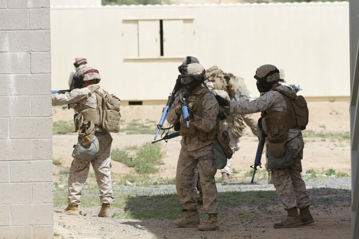 Marines participating in the Division School's Urban Leaders Course move from one building to another while carrying a casualty during a squad tactics exercise aboard Marine Corps Base Camp Pendleton, Calif., April 9, 2014. The Marines were conducting a patrol when they received contact from instructors posing as enemies. The exercise included roadside bomb simulations, gas drills and patrols that tested the Marines' proficiency in urban combat tactics. (U.S. Marine Corps photo by Lance Cpl. David Silvano/released)