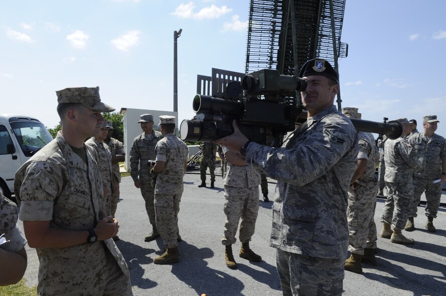 U.S. Marine Corps Lance Cpl. Robert Chambers, Air Control Squadron 4 low air defense detachment, briefs U.S. Air Force Airman 1st Class Matthew Keeling, 18th Security Forces Squadron response force member, on how to operate an FIM-92 Stinger during an air defense demonstration on Marine Corps Air Station Futenma, Japan, April 15, 2014. The FIM-92 Stinger is a personal portable infrared homing surface-to-air missile. (U.S. Air Force photo by Senior Airman Marcus Morris)