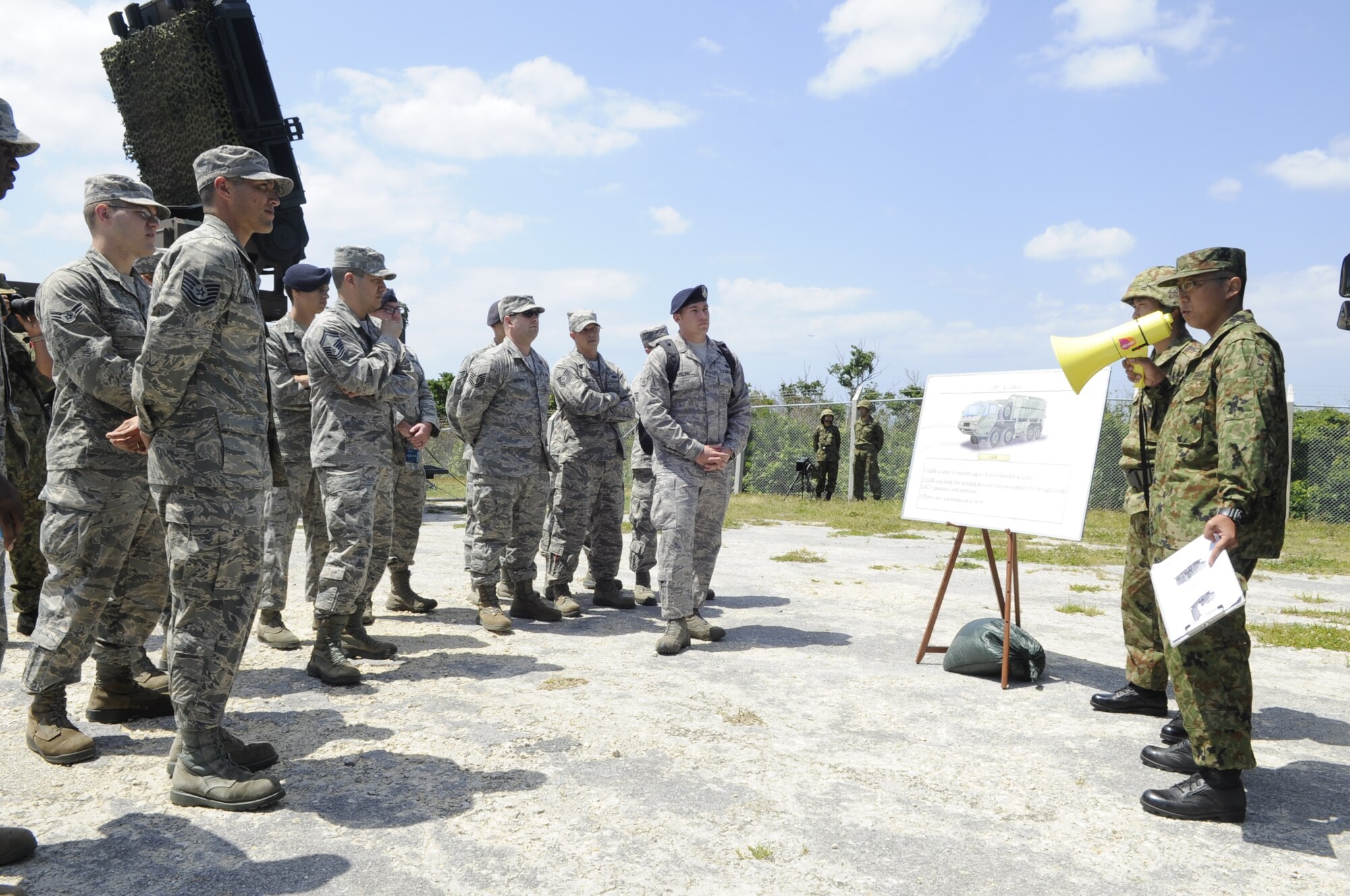 The 18th Security Forces Squadron and 18th Munitions Squadron observe a launcher unit loading demonstration from the Japan Ground Self-Defense Force on Marine Corps Air Station Futenma, Japan, April 15, 2014. The demonstration allowed the 18th SFS and 18th MUNS to learn the difference between their loading mission and the assets the 18th SFS is defending. (U.S. Air Force photo by Senior Airman Marcus Morris)