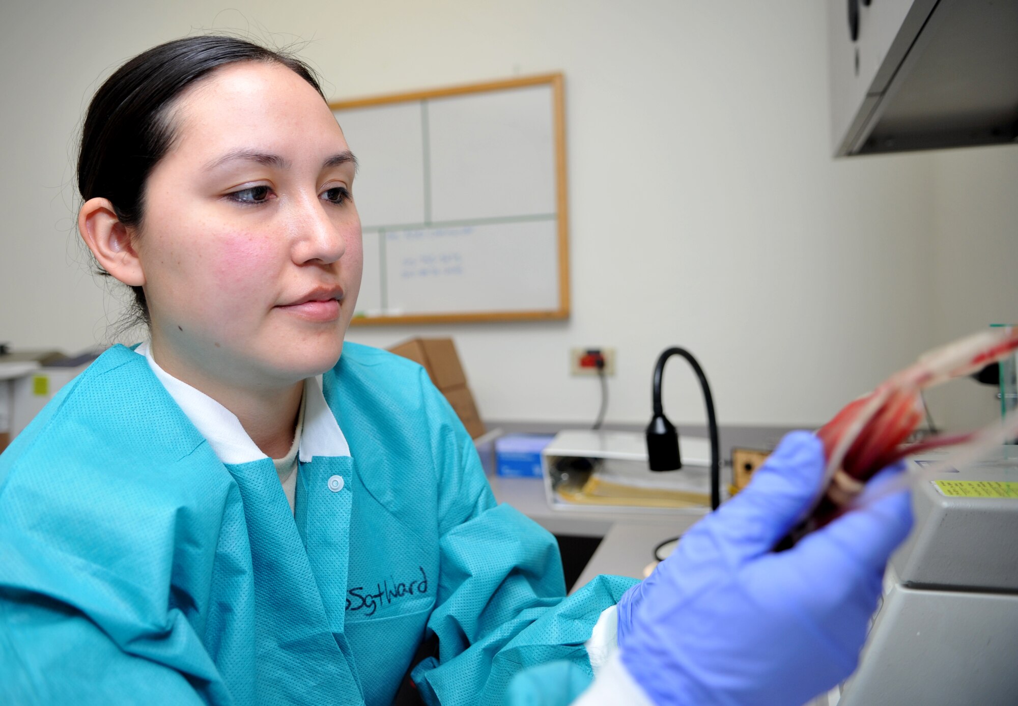 Staff Sgt. Hayli Ward, 51st Medical Support Squadron medical laboratory technician, inspects a bag of O positive blood in the 51st Medical Group at Osan Air Base, Republic of Korea, April 17, 2014. Ward and her fellow lab technicians are responsible for testing blood and bodily fluids for signs of infection or other maladies. (U.S. Air Force photo/Airman 1st Class Ashley J. Thum)