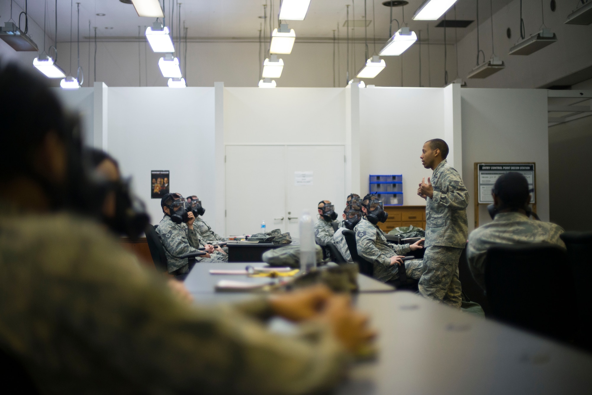 Staff Sgt. Sheraz Cedeno, 374th Civil Engineer Squadron, instructs Airmen during chemical, biological, radiological and nuclear defense training April. 17, 2014 at Yokota Air Base, Japan. Cedeno ensured each member had the necessary gear and was trained on proper use and maintenance. (U.S. Air Force photo by Staff Sgt. Chad C. Strohmeyer/Released)
