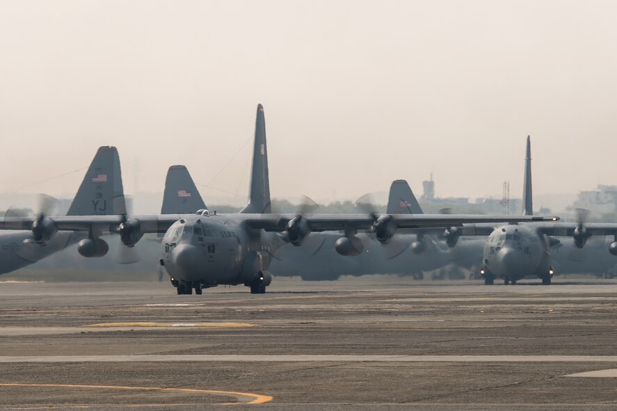 Two C-130 Hercules from the 36th Airlift Squadron taxi out to support regional operations at Yokota Air Base, Japan, April 16, 2014. The training tested Yokota’s ability to perform large-force employment and tactics. (U.S. Air Force photo by Osakabe Yasuo/Released)