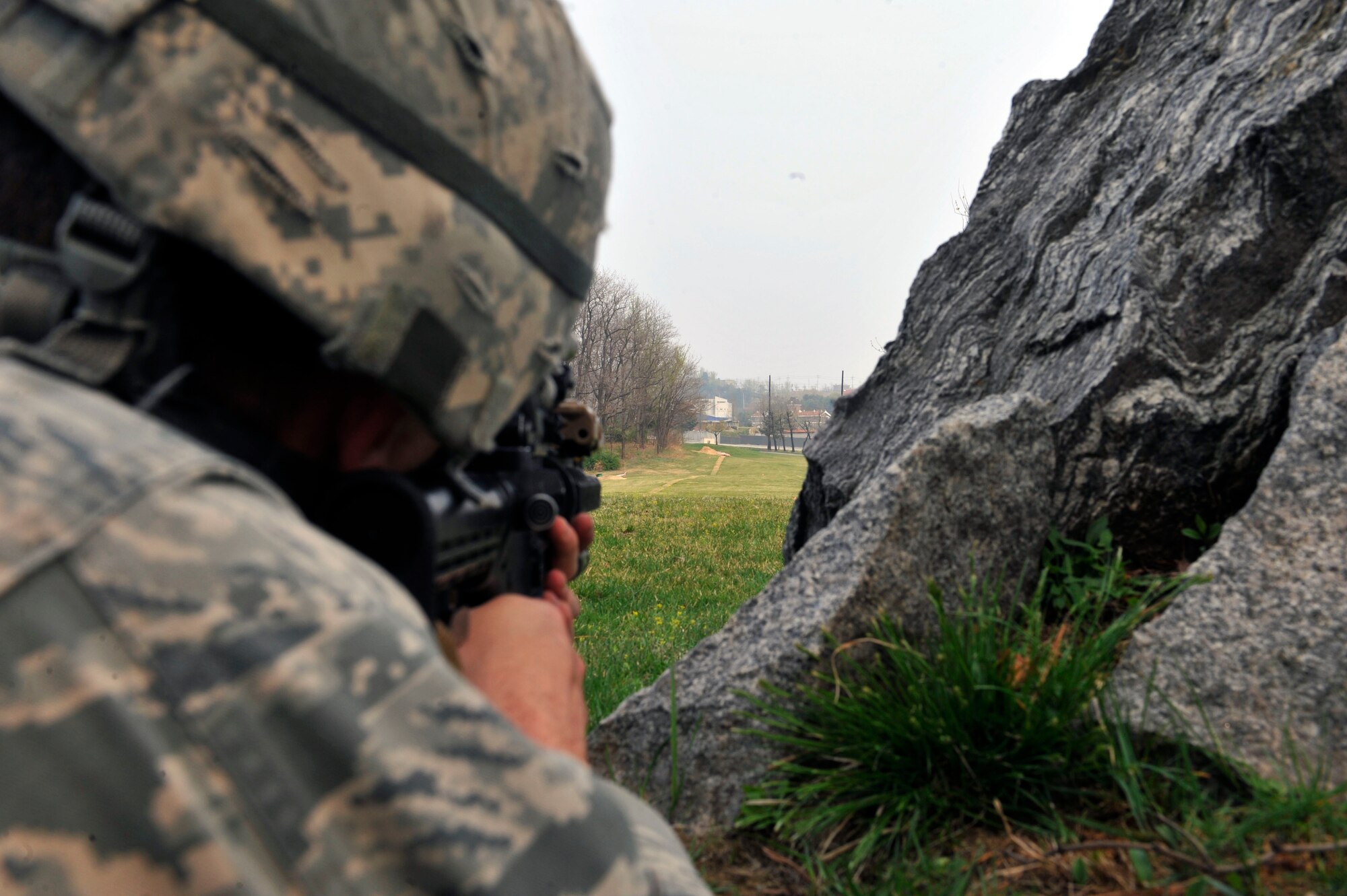 Airman Christopher Pendley, 51st Security Forces Squadron entry controller, stands guard as his squad sets up a perimeter around a building at the Rush Park and Life Support site at Osan Air Base, Republic of Korea, April 15, 2014. SFS members also went through mounted and dismounted operations training, weapon and radio familiarization and force-on-force training. (U.S. Air Force photo by Senior Airman David Owsianka)