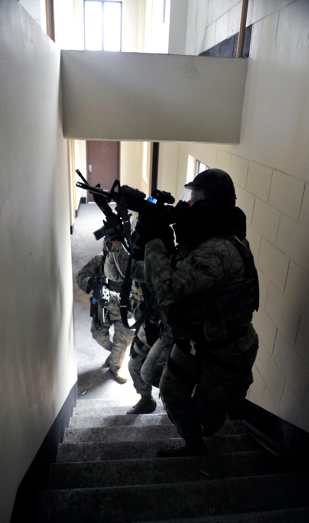 Members of the 51st Security Forces Squadron move up the stairs during a building clearing and close quarters battling scenario at the Rush Park and Life Support site at Osan Air Base, Republic of Korea, April 15, 2014. SFS members also went through mounted and dismounted operations training, weapon and radio familiarization and force-on-force training. (U.S. Air Force photo by Senior Airman David Owsianka)