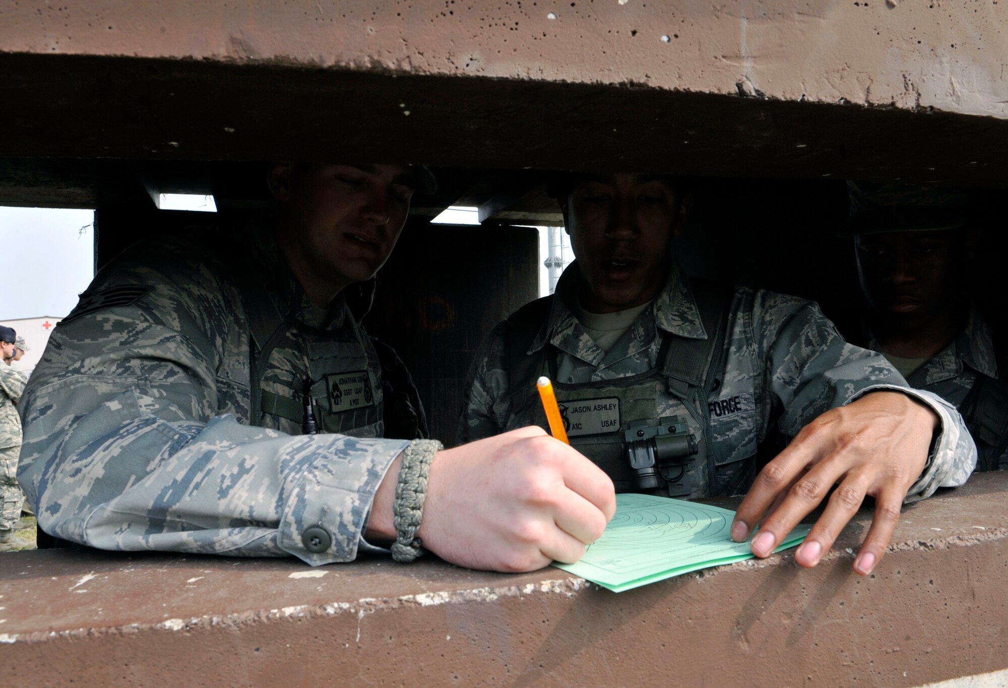 Staff Sgt. Jonathan Lee, 51st Security Forces Squadron military working dog handler, instructs Airman 1st Class Jason Ashley, 51st SFS entry controller, on how to properly fill out a range card for the defense fighting position at the Rush Park and Life Support site at Osan Air Base, Republic of Korea, April 15, 2014. Range cards inform Airmen of different avenues of approach and distance between objects. (U.S. Air Force photo by Senior Airman David Owsianka)