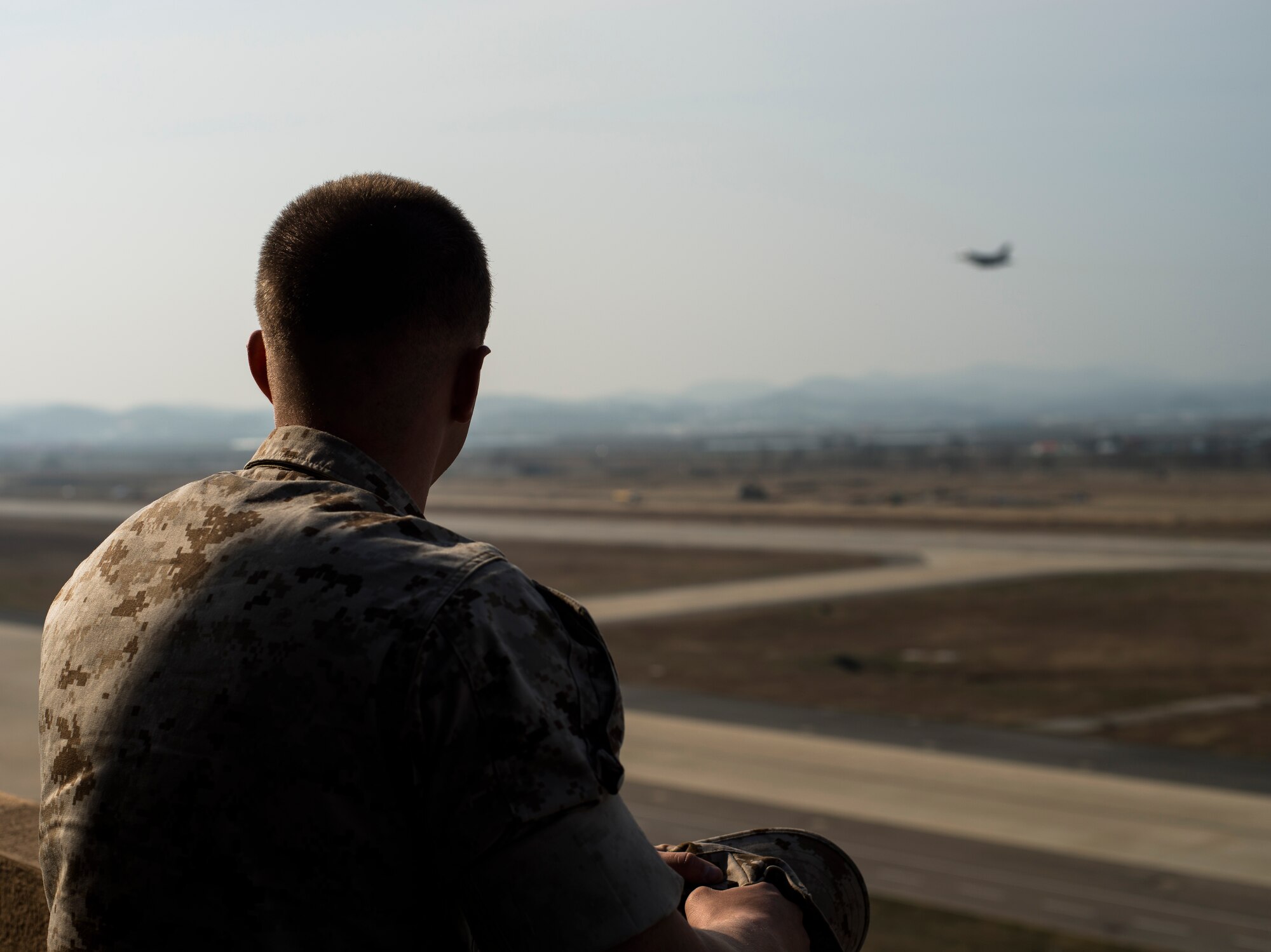 Marine Corps Cpl. Jake Balcom watches an F-16 take off March 26, 2014, at Osan Air Base, Republic of Korea. Balcom's grandfather, Col. Ralph Balcom, served as a fighter pilot in Vietnam, but has been missing in action since May 15, 1966. (U.S. Air Force photo by Staff Sgt. Jake Barreiro)