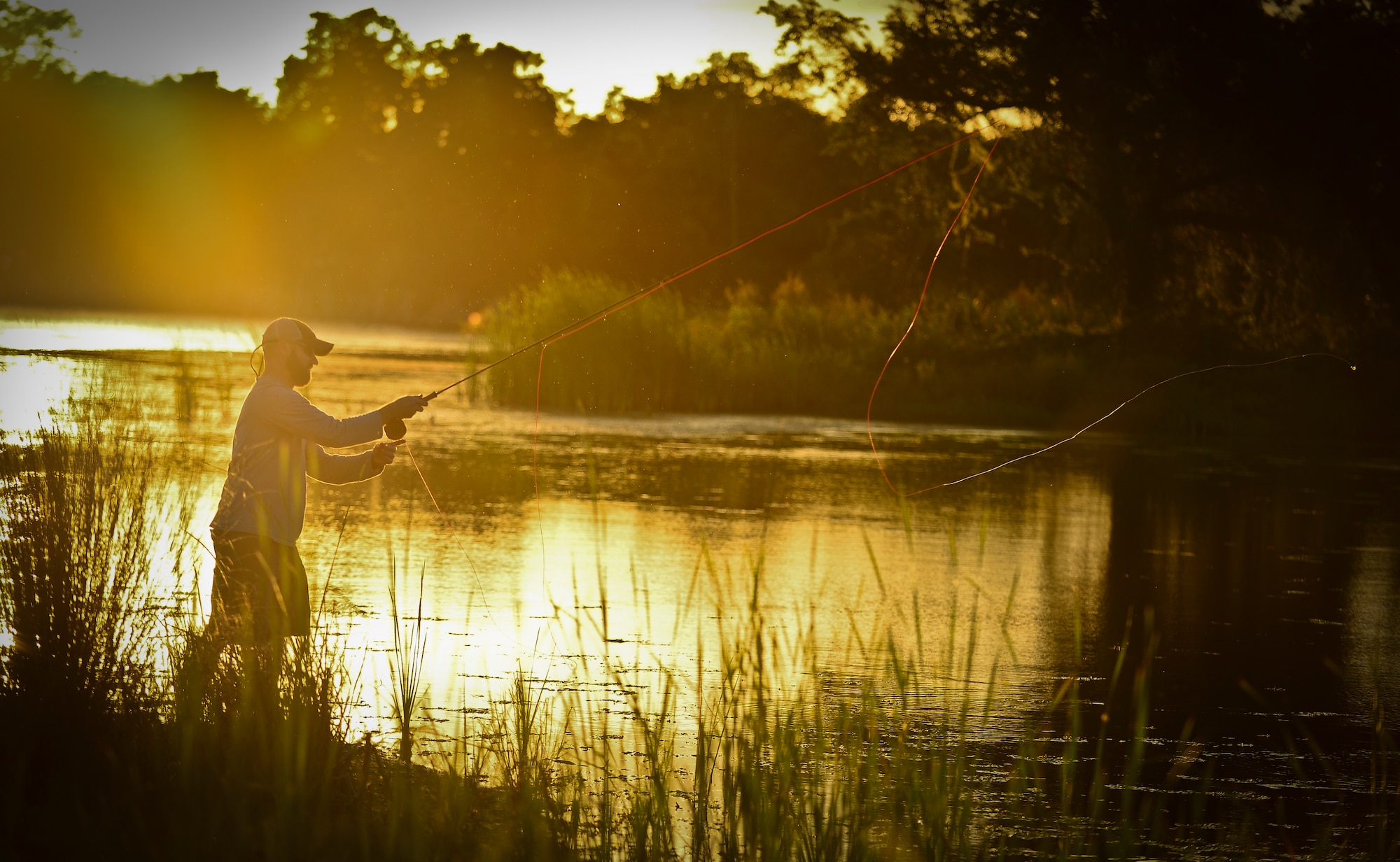 James Custer, a Project Healing Waters Fly Fishing participant, practices newly learned casting techniques at MacDill Air Force Base, Fla., April 17, 2014.  The group’s most recent outing took place at MacDill Air Force Base’s Lewis Lake, where volunteers aided participants as they honed their new-found casting skills and dipped their freshly tied flies. (U.S. Air Force photo by Staff Sgt. Brandon Shapiro/Released)