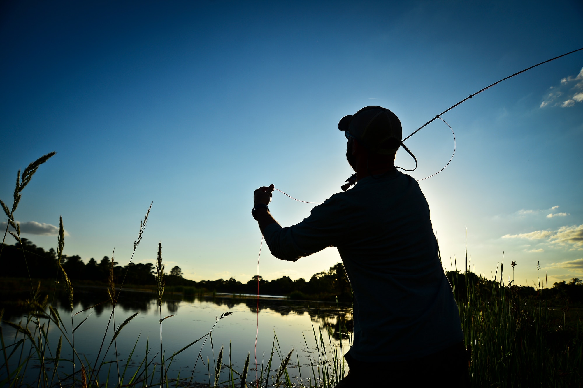 James Custer, a Project Healing Waters Fly Fishing participant, practices newly learned casting techniques at MacDill Air Force Base, Fla., April 17, 2014.  The group’s most recent outing took place at MacDill Air Force Base’s Lewis Lake, where volunteers aided participants as they honed their new-found casting skills and dipped their freshly tied flies. (U.S. Air Force photo by Staff Sgt. Brandon Shapiro/Released)
