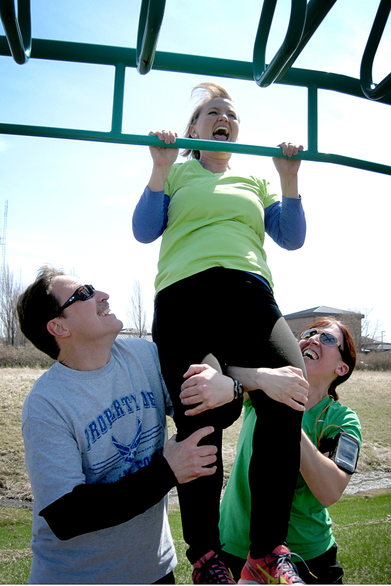 Margie Gallegos gets a boost from teammates Jeff Castleberry and Debra Wilson-Strong as she does a pull up during an Easter Egg fun run held at Grissom Air Reserve Base, Ind., April 17, 2014. Teams of runners ran along the 5K course stopping to perform a variety of unity-building exercises in the name of fun and fitness. (U.S. Air Force photo/Tech. Sgt. Douglas Hays)