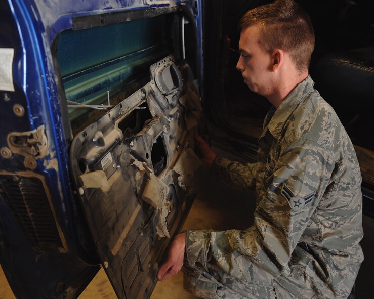 Airman 1st Class Austin Beam, 2nd Logistics Readiness Squadron Vehicle Maintenance Allied Trades section, removes a vehicle's door panel in order to get to the window regulator on Barksdale Air Force Base, La., April 16, 2014. The window regulator is the part that raises and lowers the window. (U.S. Air Force photo/Senior Airman Benjamin Gonsier) 